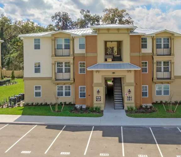 the exterior of an apartment building with a driveway