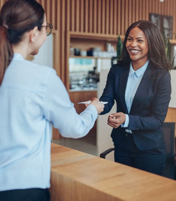two women shaking hands at a hotel reception desk at The Sutton, Georgia, 30305