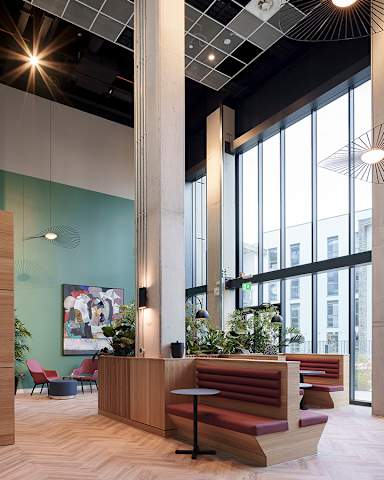 A modern office lobby with a wooden reception desk and a large window.