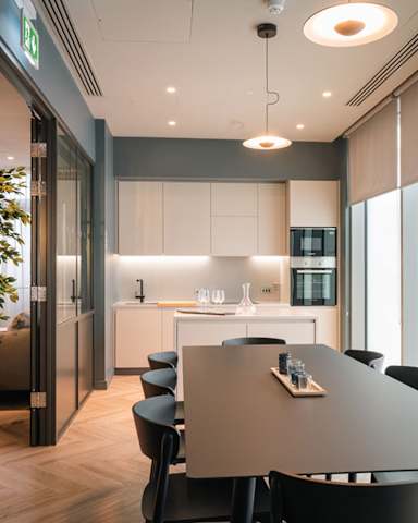 A modern kitchen with a dining table and chairs.