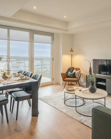 A modern living room with a dining table and chairs.
