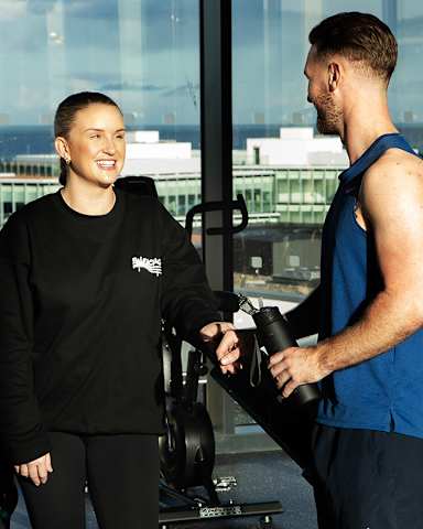 A man and a woman are working out together in a gym.