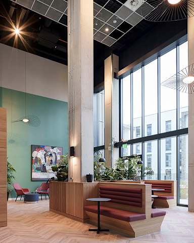 A modern office space with a wooden reception desk and red seating.
