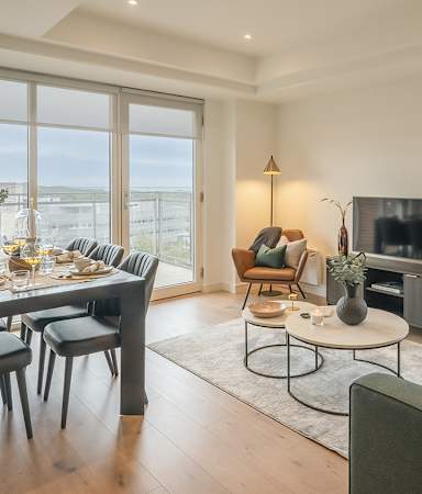 A modern living room with a dining table and chairs.
