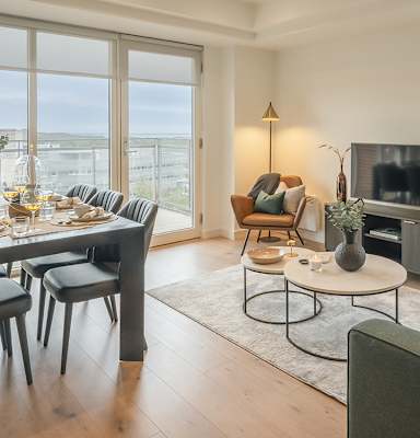 A modern living room with a dining table and chairs.