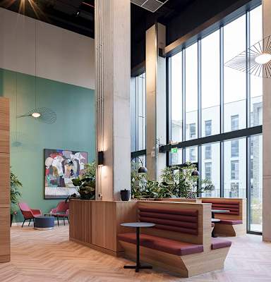 A modern office lobby with a wooden reception desk and a large window.
