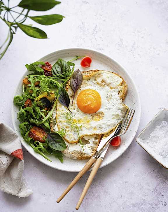 A plate of food with a fried egg on top of a slice of bread. at Roxy Apartments, Hamilton, ON, L8H 0B7