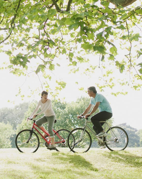 a couple riding bikes in a park