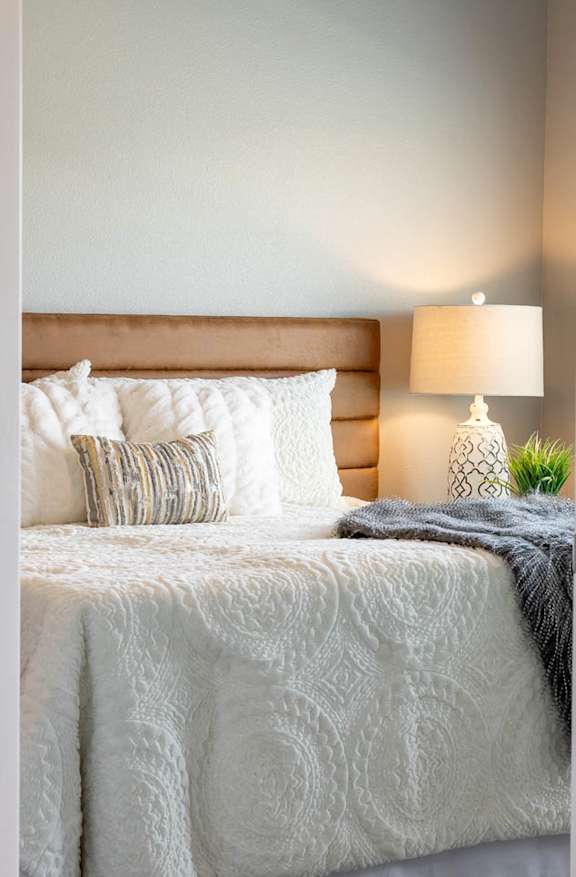 a bedroom with a white bed and pillows on it