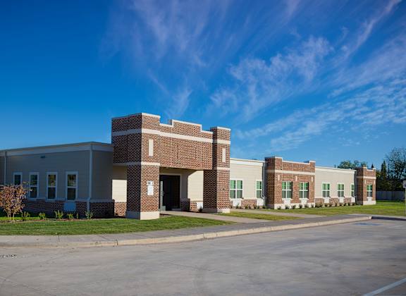 A large building with a parking lot in front.