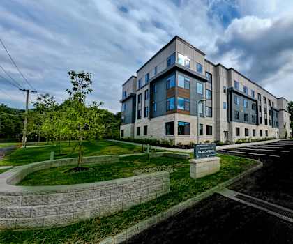 A modern building with a parking lot in front.