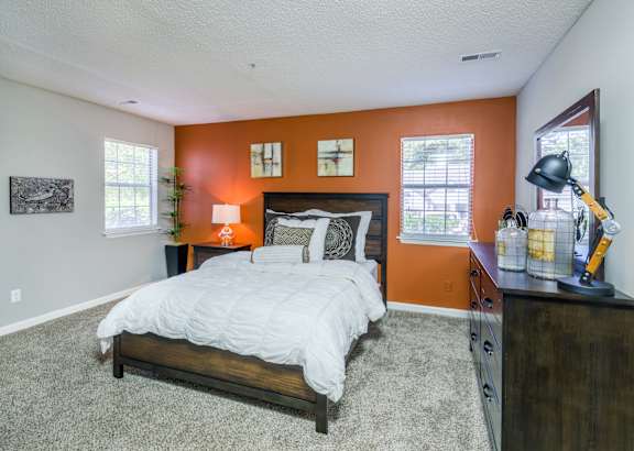 A bedroom with a bed, nightstand, and a lamp. at Woodwinds, Aiken, 29803