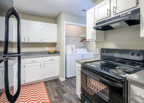 A black stove in a kitchen with white cabinets. at Woodwinds, Aiken, 29803