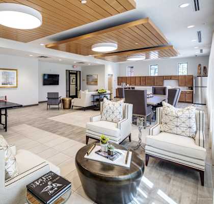 a clubhouse with couches and chairs and a ping pong table