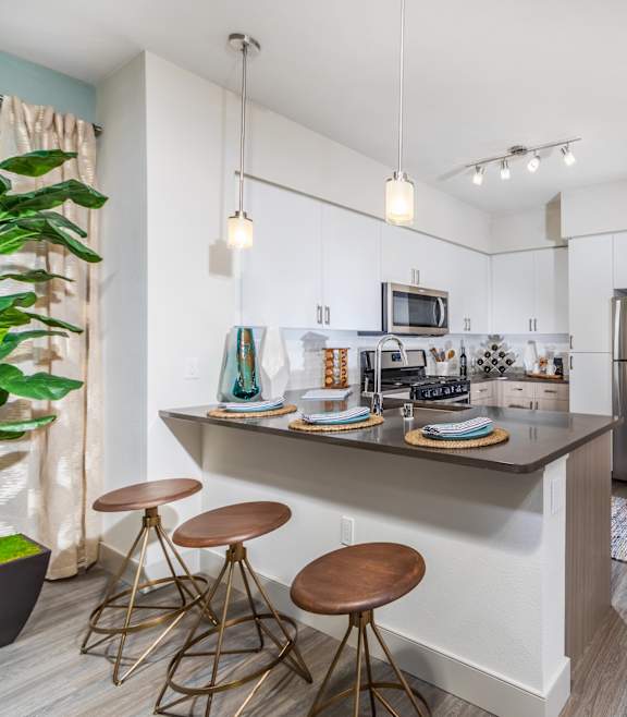A kitchen with a bar area and a refrigerator.