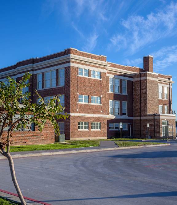A modern apartment complex with a well-maintained lawn in front.