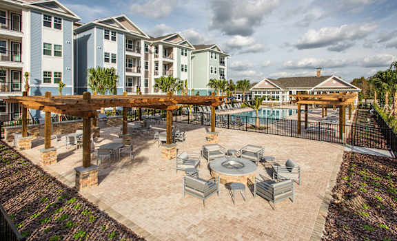 an outdoor patio with tables and chairs and a pool