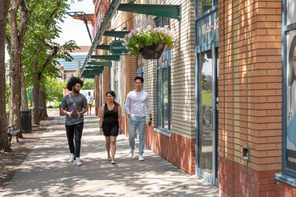 a group of people walking down a sidewalk