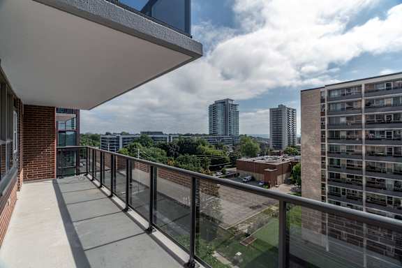 A balcony with a glass railing overlooks a cityscape. at 70 Park, California, L5G 1M5