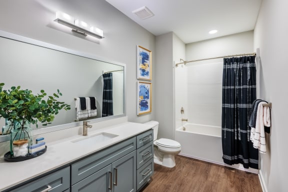 a bathroom with gray cabinets and a white countertop