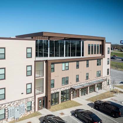 A modern building with a parking lot in front.