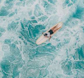 A person is surfing on a wave in the ocean.