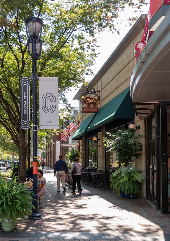people walking down a sidewalk in front of shops