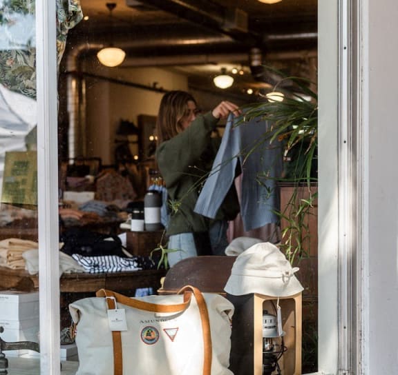 a woman in a window of a shop with bags at One West Drive Apartments, Excelsior, Minnesota