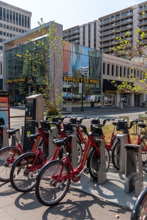 a row of red bikes parked in front of a building