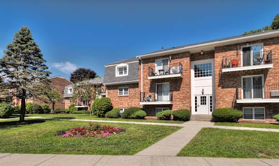 A red brick apartment building with a white door and windows at Pine Grove Apartments, Taunton, 02780