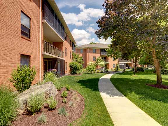 A walkway leads from a building to a grassy area. at Highland Glen Apartments, Westwood, MA, 02090