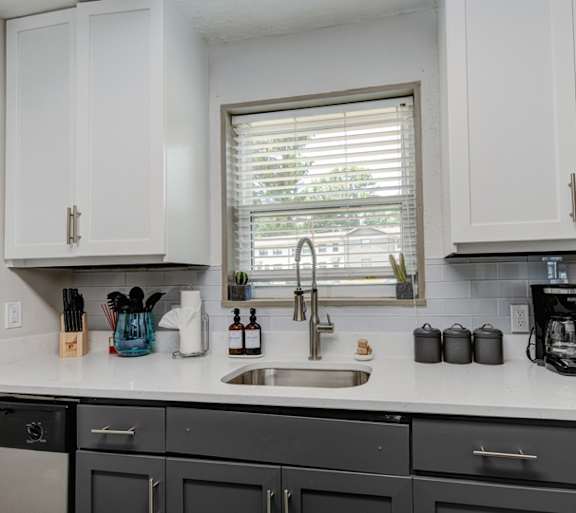 A kitchen with black cabinets and a white countertop.