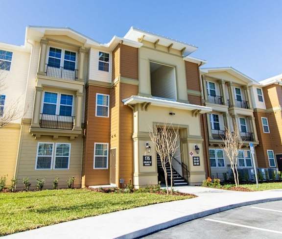 an apartment building with a sidewalk in front of it