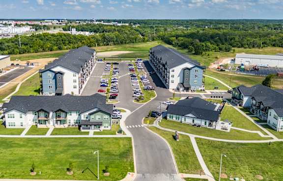 A large aerial view of a housing complex with a parking lot in the foreground.