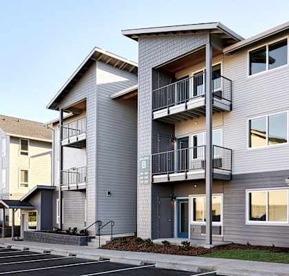 a row of townhomes with balconies and a parking lot
