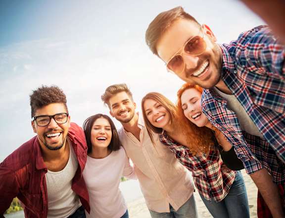a group of people posing for a picture on the beach