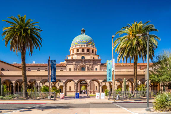 a building with a green dome and palm trees in front of it at Promontory, Tucson