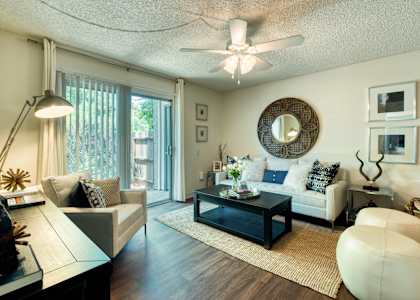 a living room with furniture and a ceiling fan at Connect on Northern Apartments, Glendale