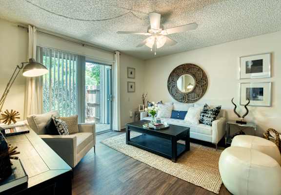 a living room with furniture and a ceiling fan at Connect on Northern Apartments, Glendale 85301
