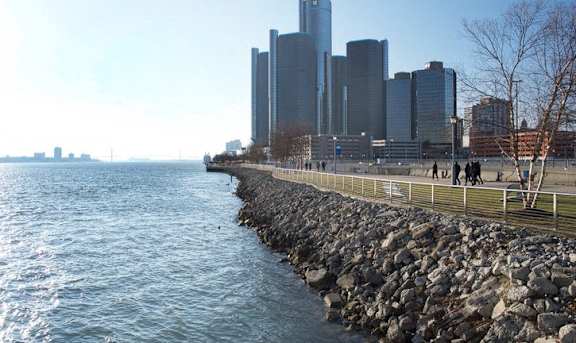 A city skyline is seen from a waterfront walkway.