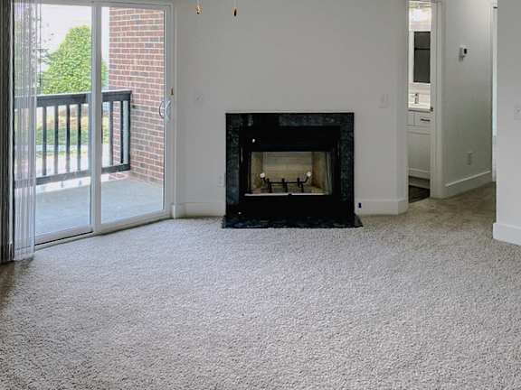 A living room with a fireplace and sliding glass doors.