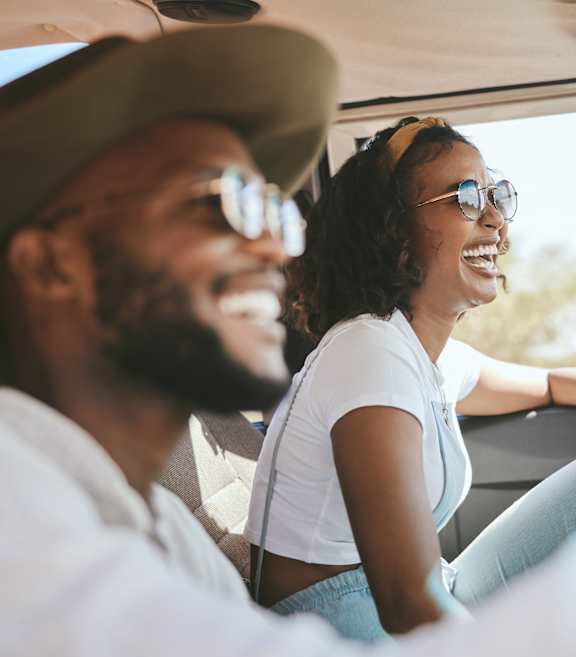 a man and woman sitting in a car and laughing