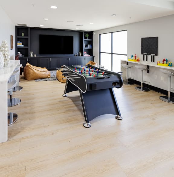 a game room with a foosball table and a tv