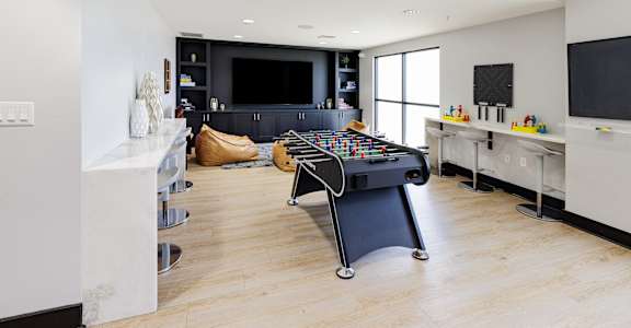 a game room with a foosball table and a tv
