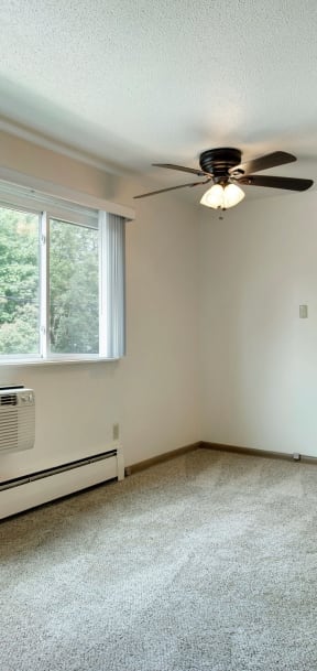 A room with a ceiling fan and a window. at Northeast Villas, Fridley, 55421