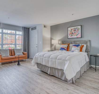 A bedroom with a large bed and a window with curtains.