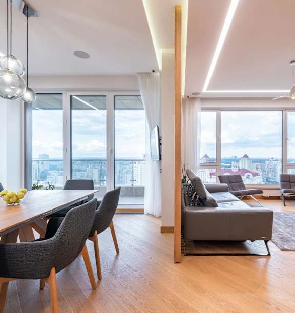 A modern living room with a dining table and chairs.