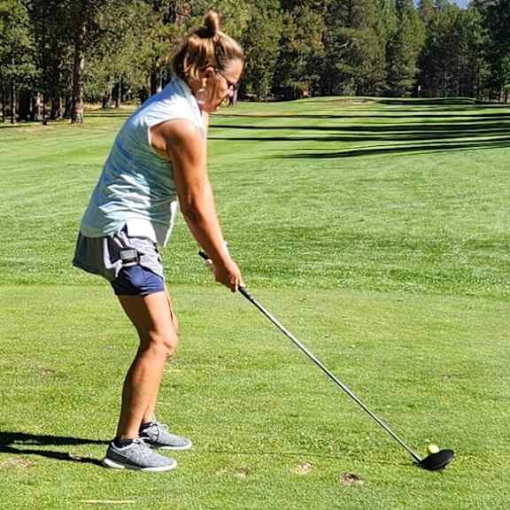 A person is playing golf on a sunny day.