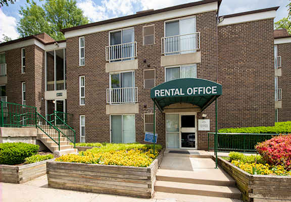 A rental office is located in a brick building with a green awning.