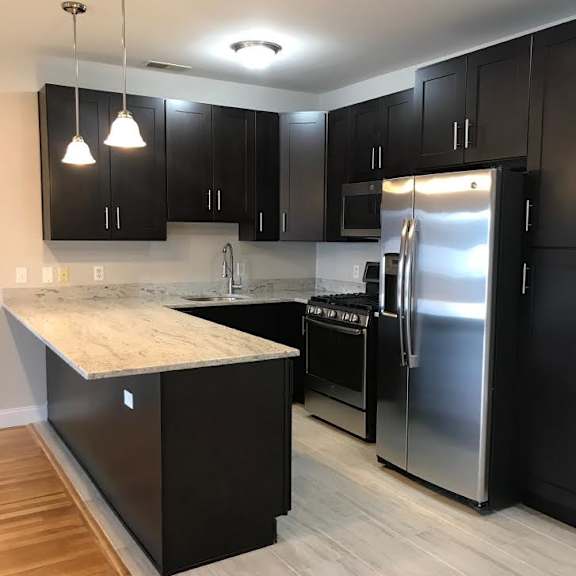 A kitchen with black cabinets and a wooden island.